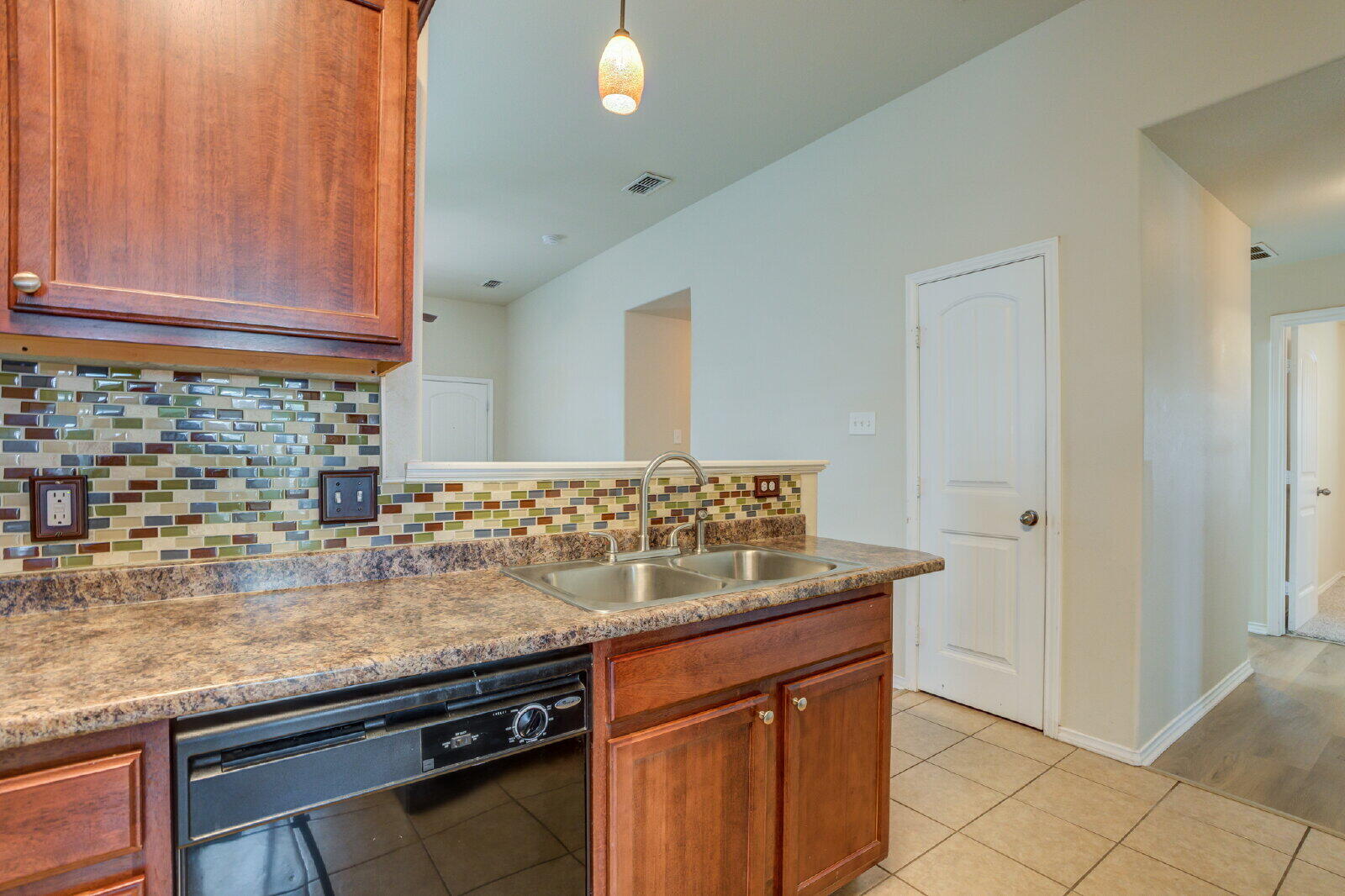 6921 95th Street Lubbock, TX 79424 - Photo 9 of 32 a kitchen with granite countertop a sink and a stove