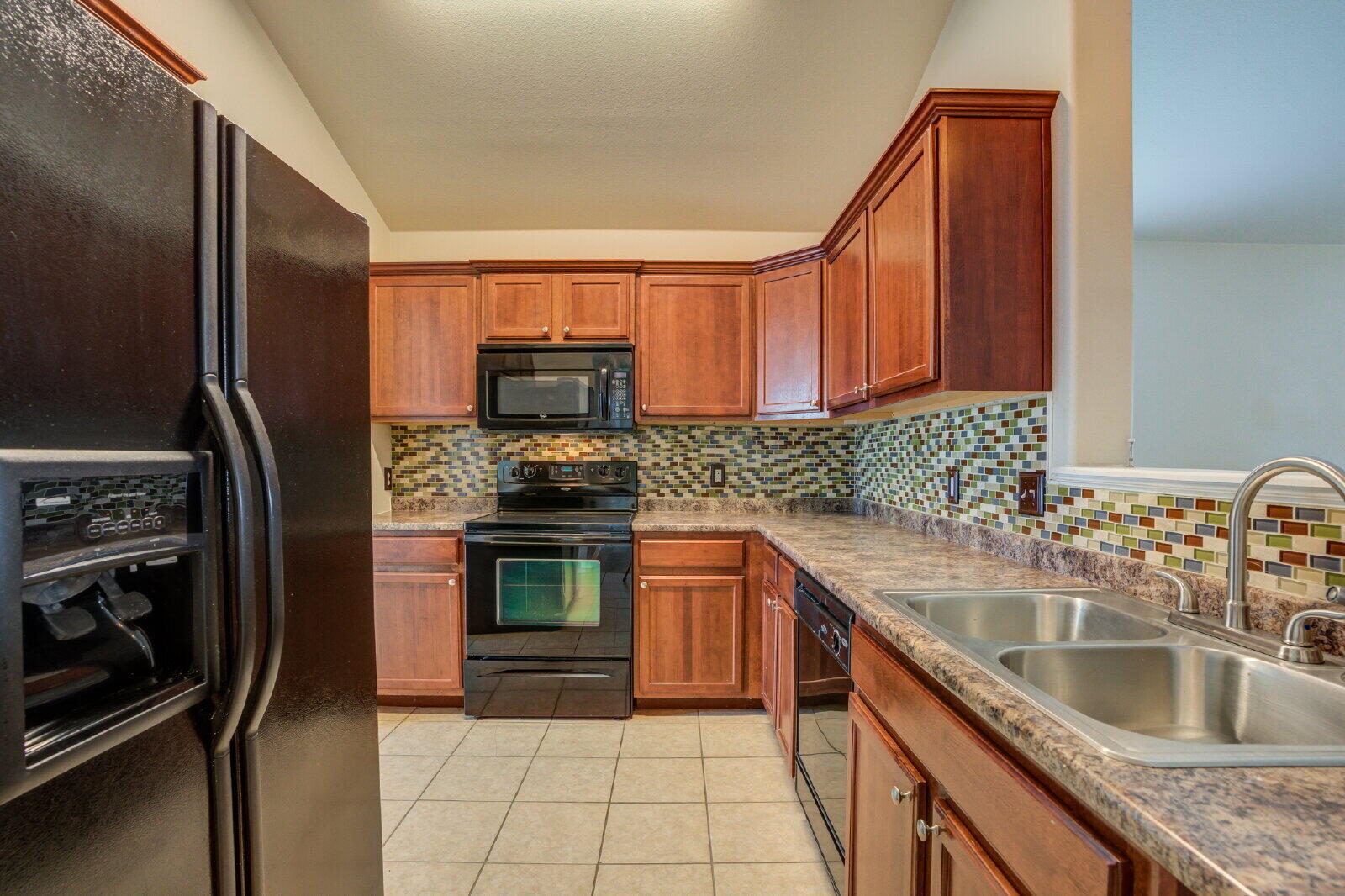 6921 95th Street Lubbock, TX 79424 - Photo 10 of 32 a kitchen with stainless steel appliances granite countertop a sink stove and refrigerator
