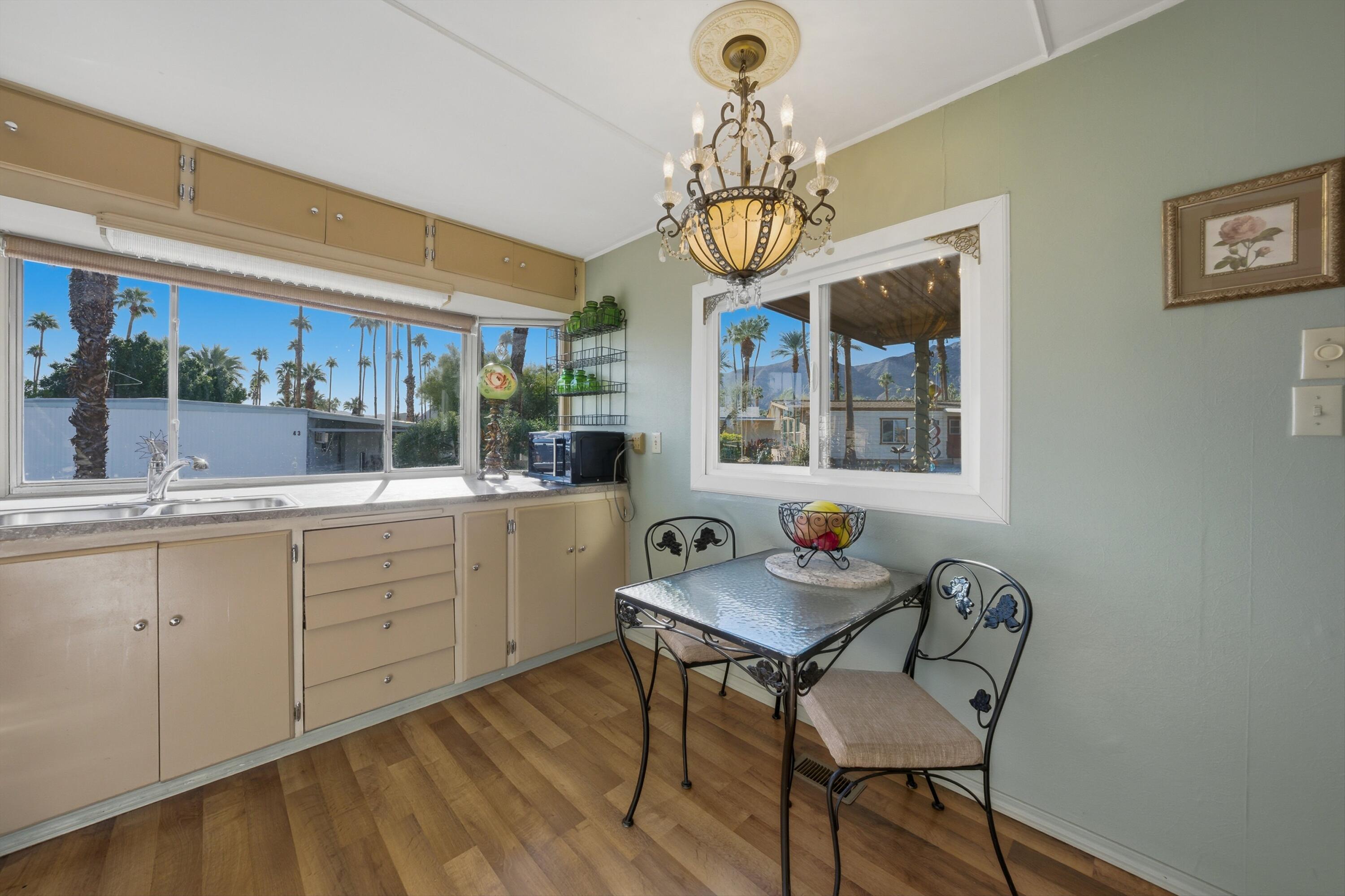 70260 Highway 111, Unit 42 Rancho Mirage, CA 92270 - Photo 21 of 35 a kitchen with a dining table chairs and chandelier