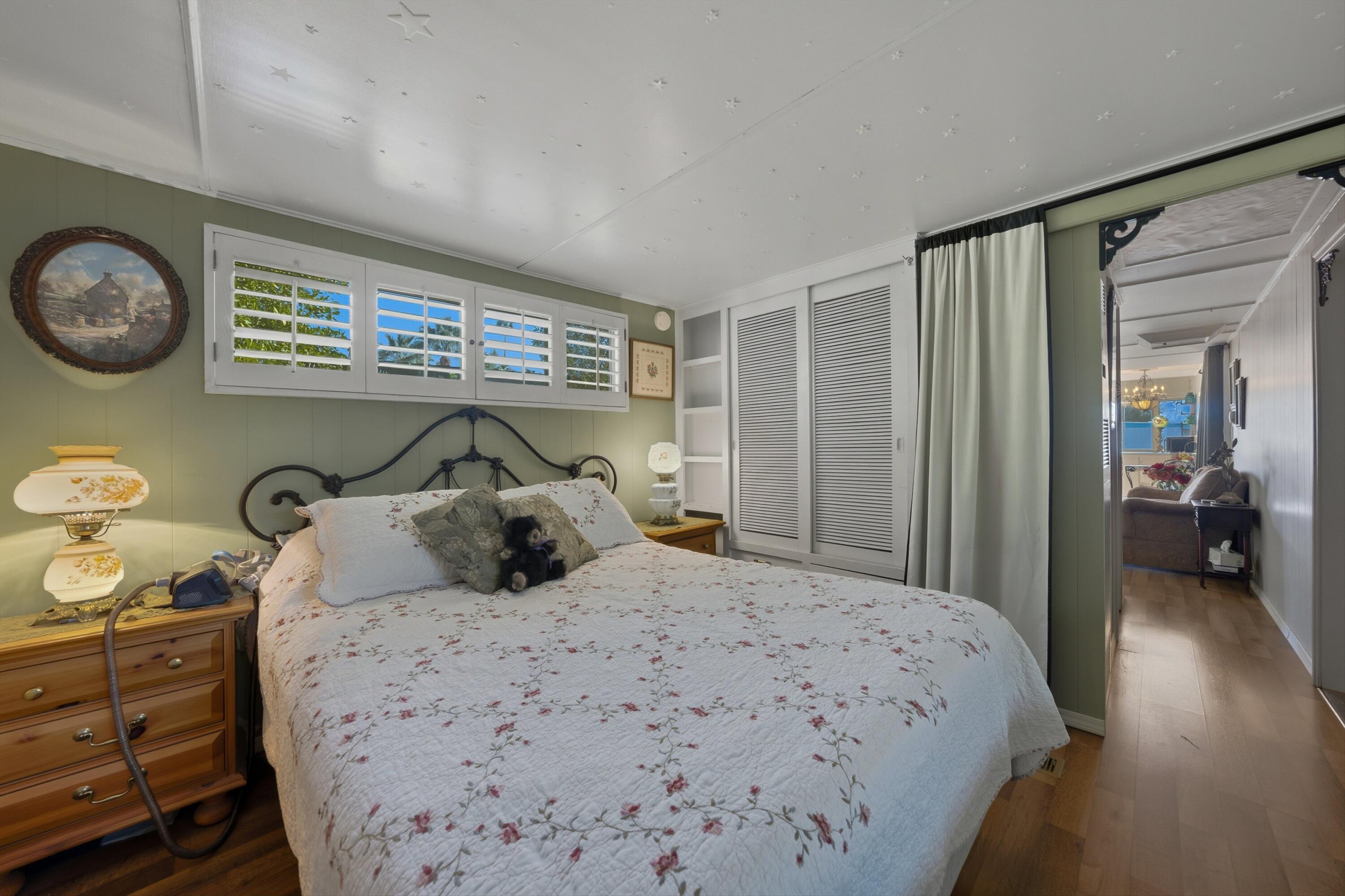 70260 Highway 111, Unit 42 Rancho Mirage, CA 92270 - Photo 23 of 35 a bedroom with a large bed and a chandelier