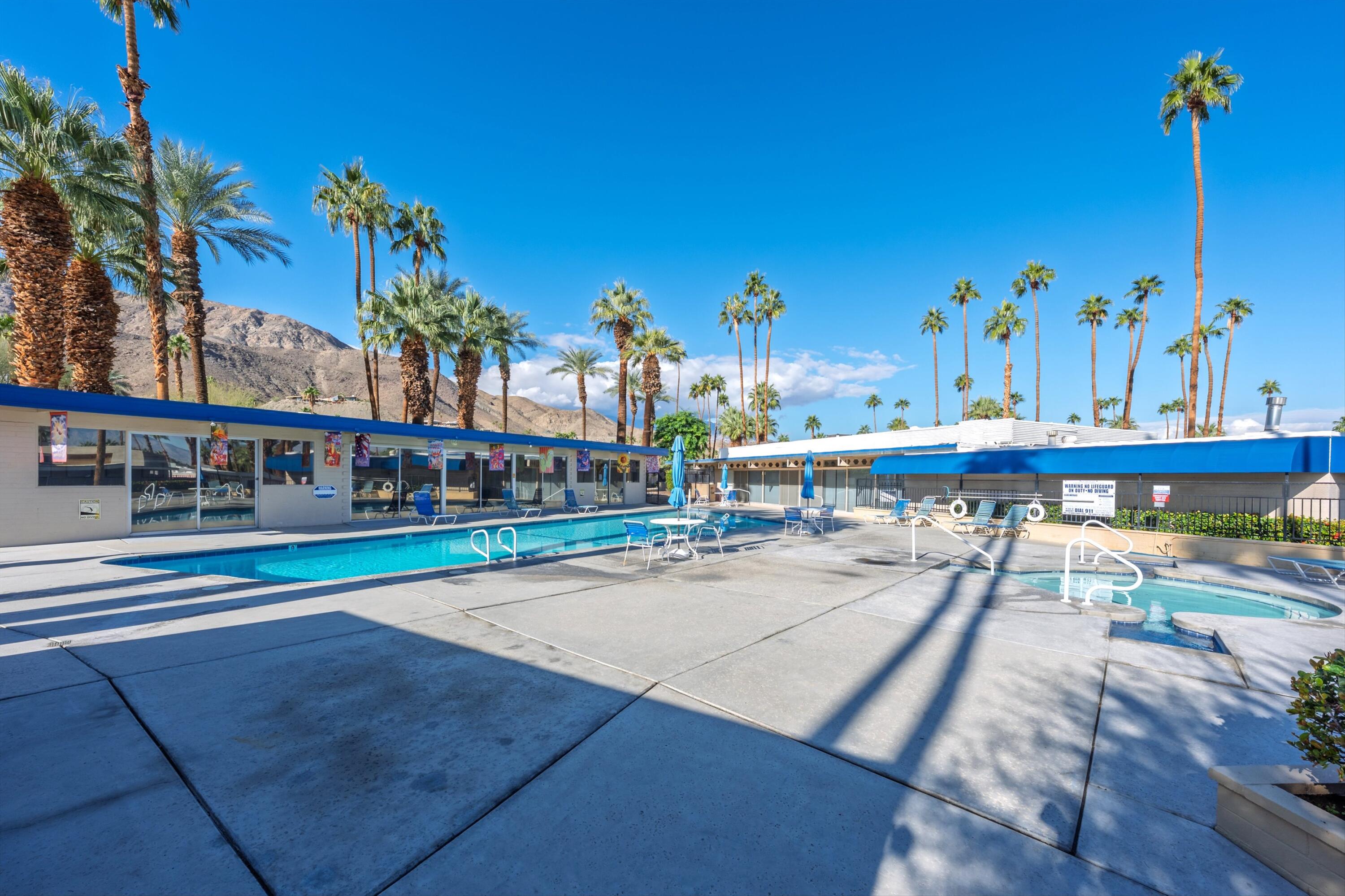 70260 Highway 111, Unit 42 Rancho Mirage, CA 92270 - Photo 30 of 35 a view of a swimming pool with a lawn chairs and potted plants