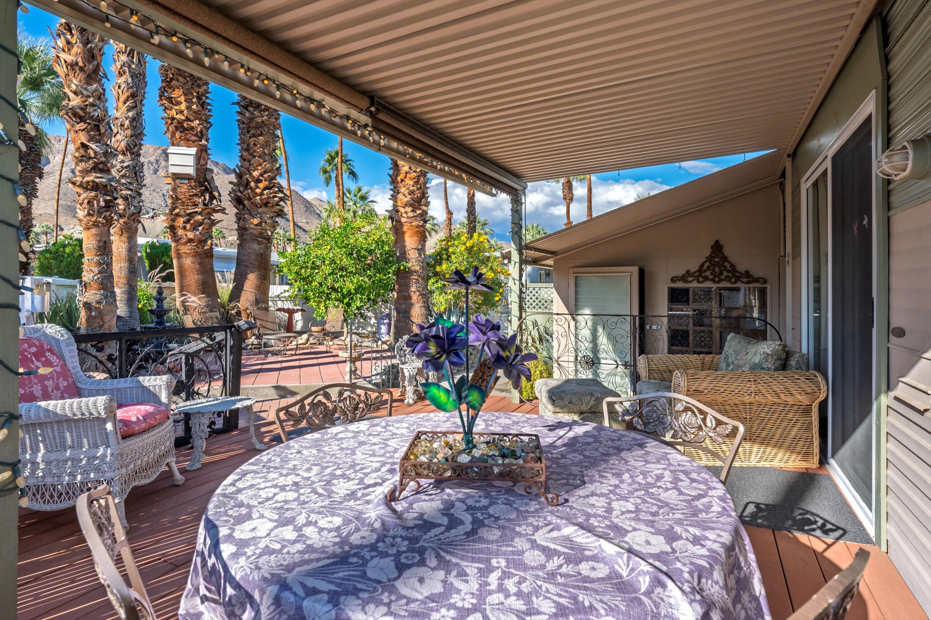 70260 Highway 111, Unit 42 Rancho Mirage, CA 92270 - Photo 3 of 35 a view of a patio with table and chairs potted plants and floor to ceiling window and potted plants