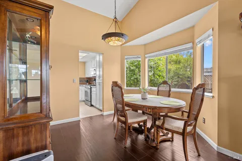 a dining room with furniture a chandelier and wooden floor