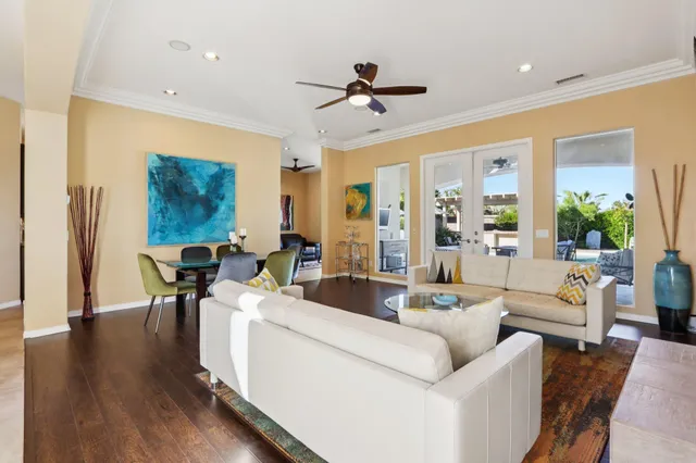 a living room with furniture kitchen view and a large window