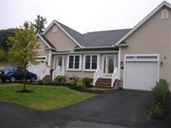 a front view of a house with a garden and trees