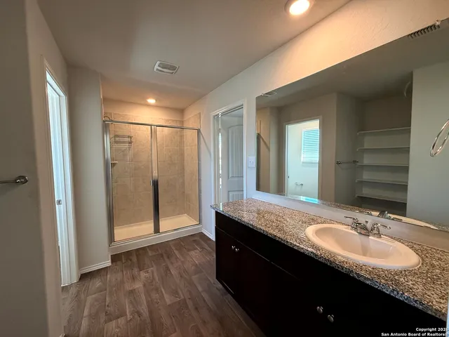 a bathroom with a granite countertop sink and a mirror