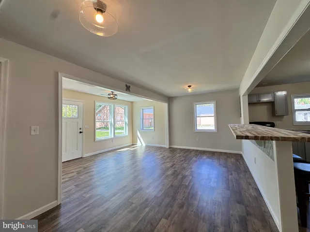 an empty room with wooden floor and a window