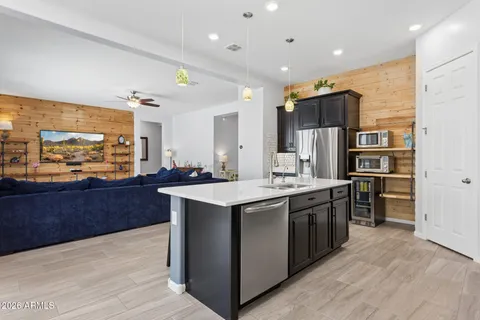 a dining room with stainless steel appliances furniture a rug and a clock