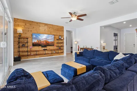 a living room with couches and kitchen view with wooden floor