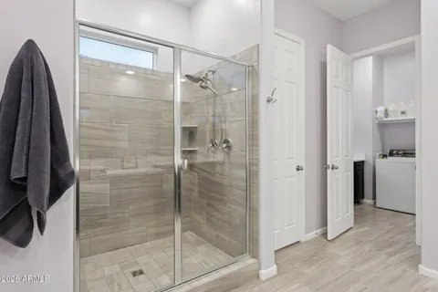 a bathroom with a sink double vanity granite tub shower and a mirror