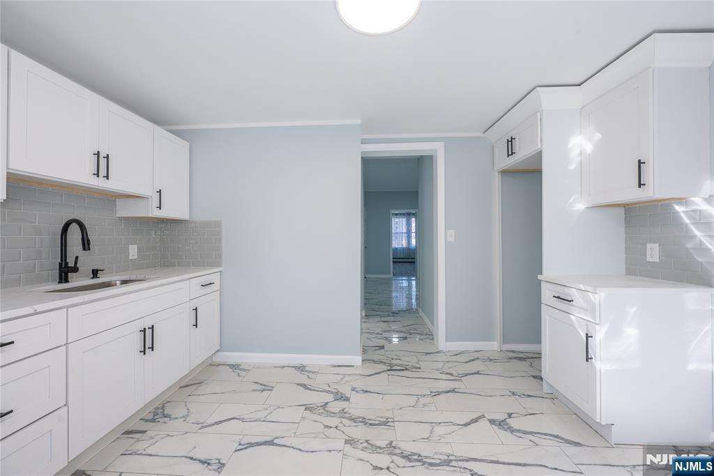 723 East 26th Street Paterson, NJ 07504 - Photo 13 of 41 a large white kitchen with sink and cabinets