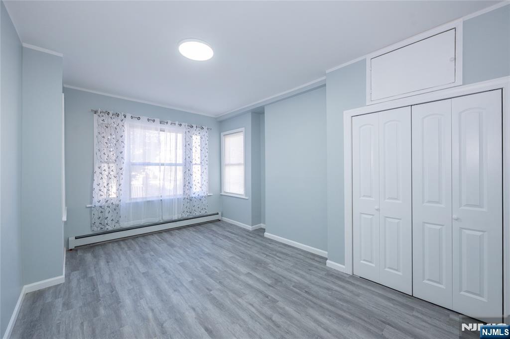 723 East 26th Street Paterson, NJ 07504 - Photo 2 of 41 an empty room with wooden floor and windows