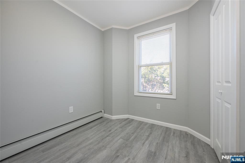723 East 26th Street Paterson, NJ 07504 - Photo 22 of 41 an empty room with wooden floor and windows