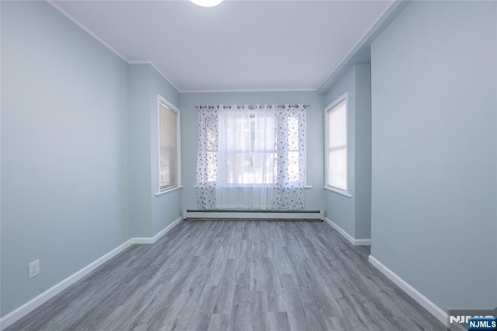 723 East 26th Street Paterson, NJ 07504 - Photo 3 of 41 an empty room with wooden floor and windows