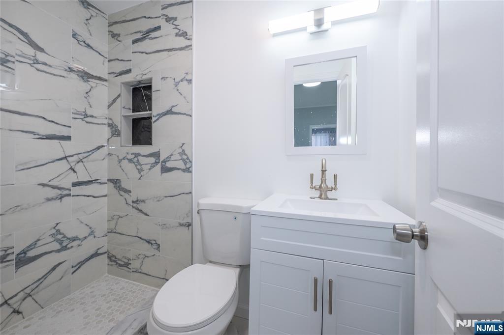 723 East 26th Street Paterson, NJ 07504 - Photo 8 of 41 a bathroom with a sink toilet vanity and shower