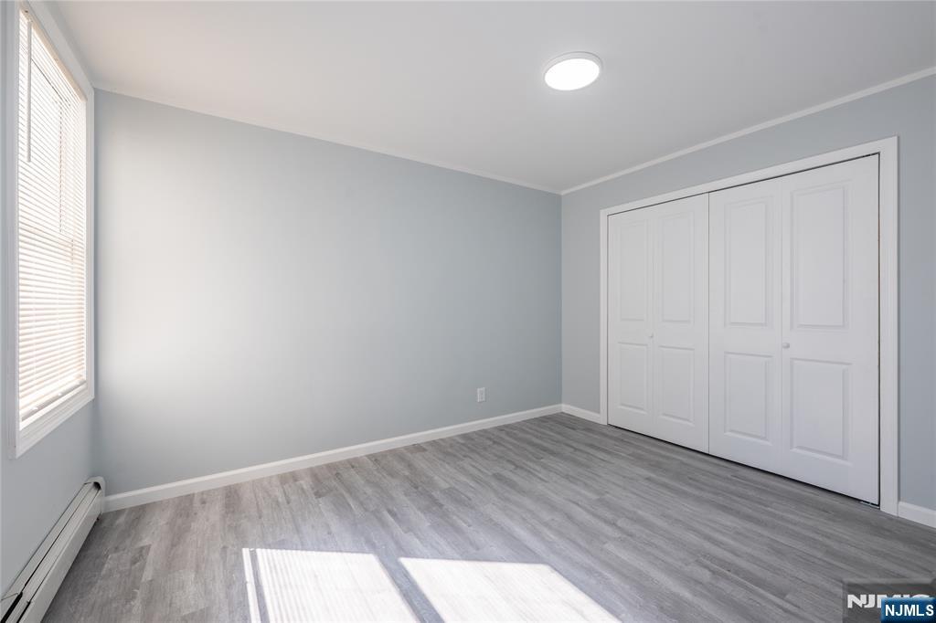 723 East 26th Street Paterson, NJ 07504 - Photo 9 of 41 an empty room with wooden floor and windows