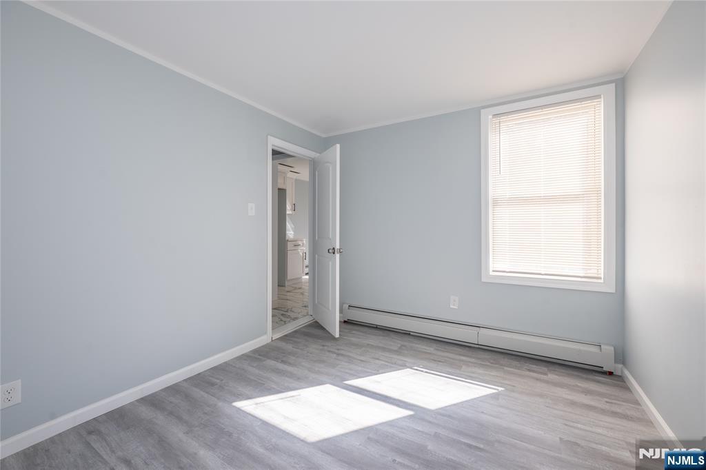 723 East 26th Street Paterson, NJ 07504 - Photo 10 of 41 an empty room with wooden floor and windows