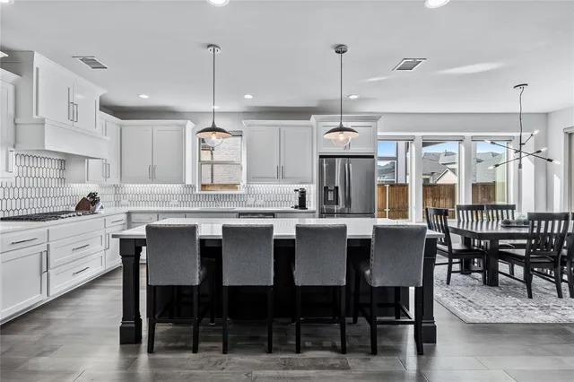 a large kitchen with a table and chairs