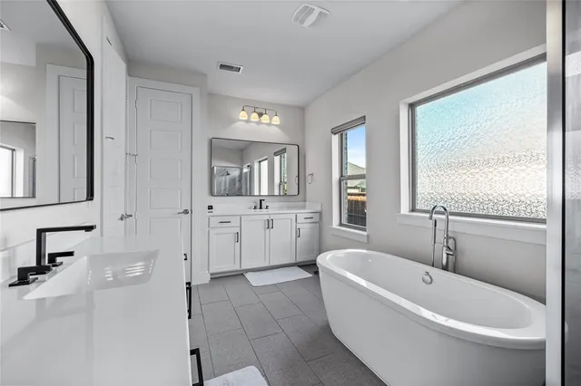 a bathroom with a bathtub sink and mirror