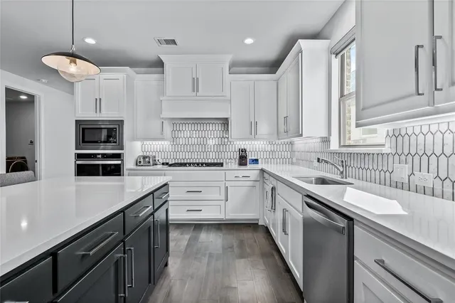 a kitchen with white cabinets and appliances