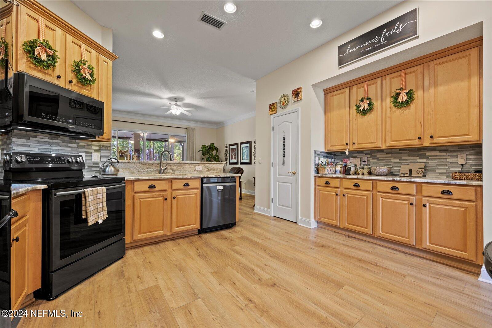 1283 Paradise Pond Road St. Augustine, FL 32092 - Photo 11 of 47 a kitchen with stainless steel appliances granite countertop a stove top oven a sink dishwasher and a microwave oven with cabinets
