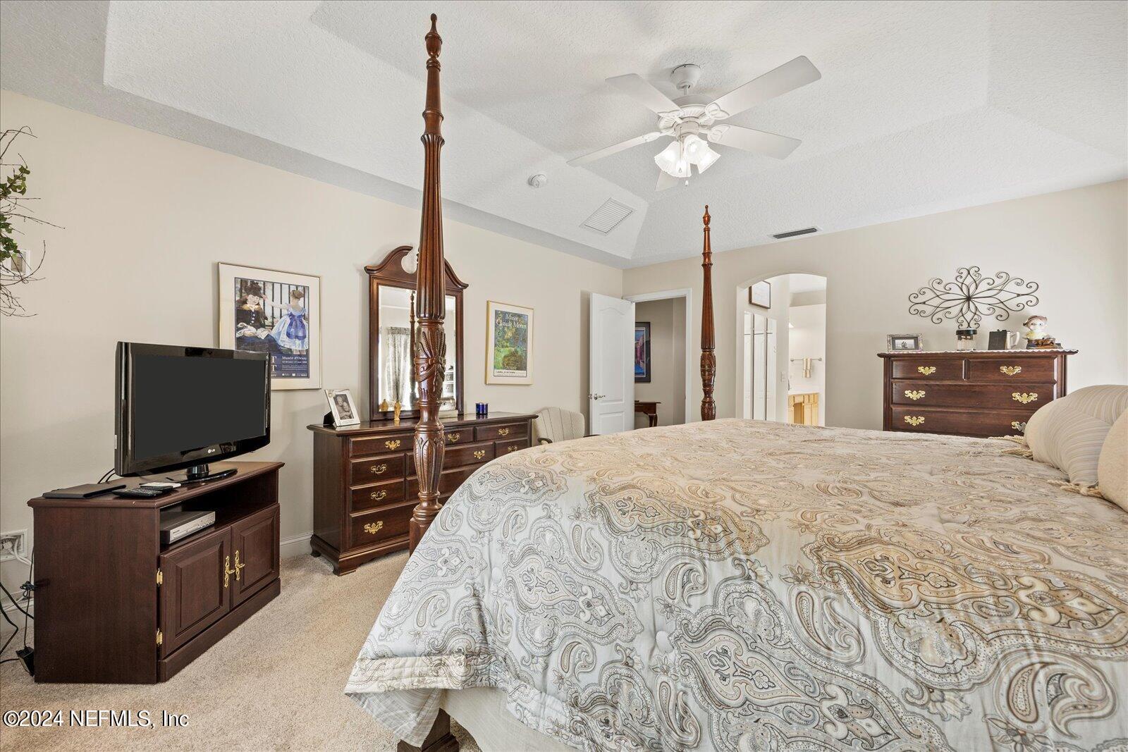 1283 Paradise Pond Road St. Augustine, FL 32092 - Photo 20 of 47 a bedroom with a bed and a flat tv screen on dresser