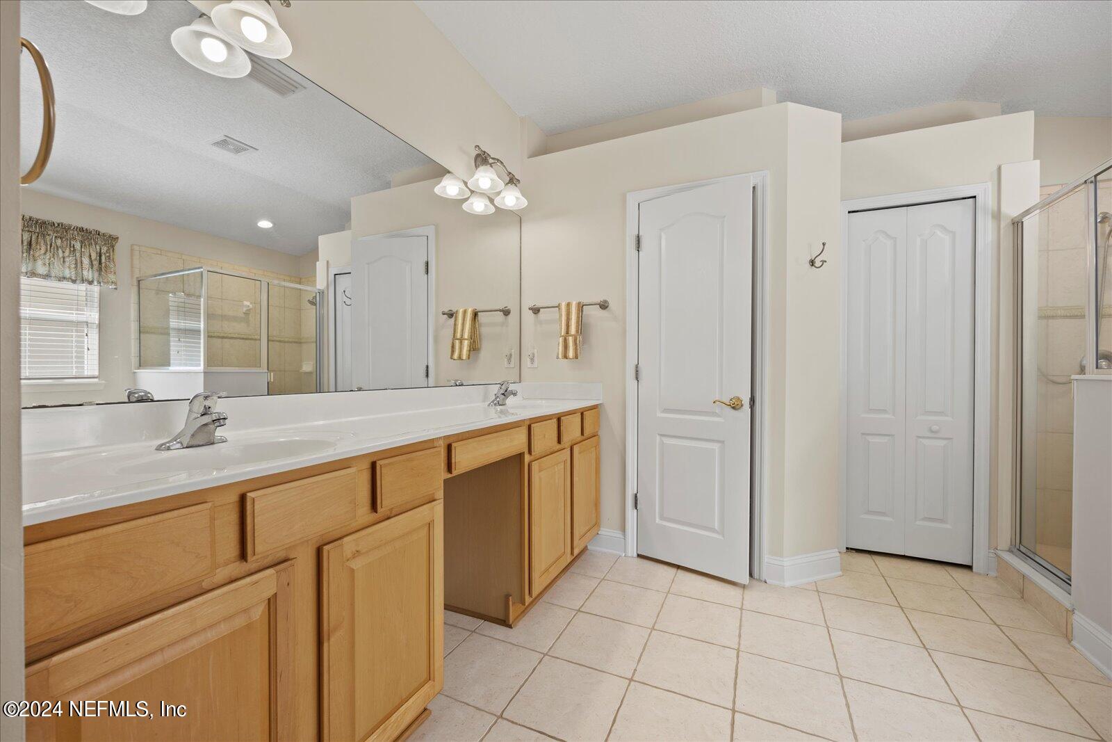 1283 Paradise Pond Road St. Augustine, FL 32092 - Photo 22 of 47 a spacious bathroom with a granite countertop sink a mirror and a shower