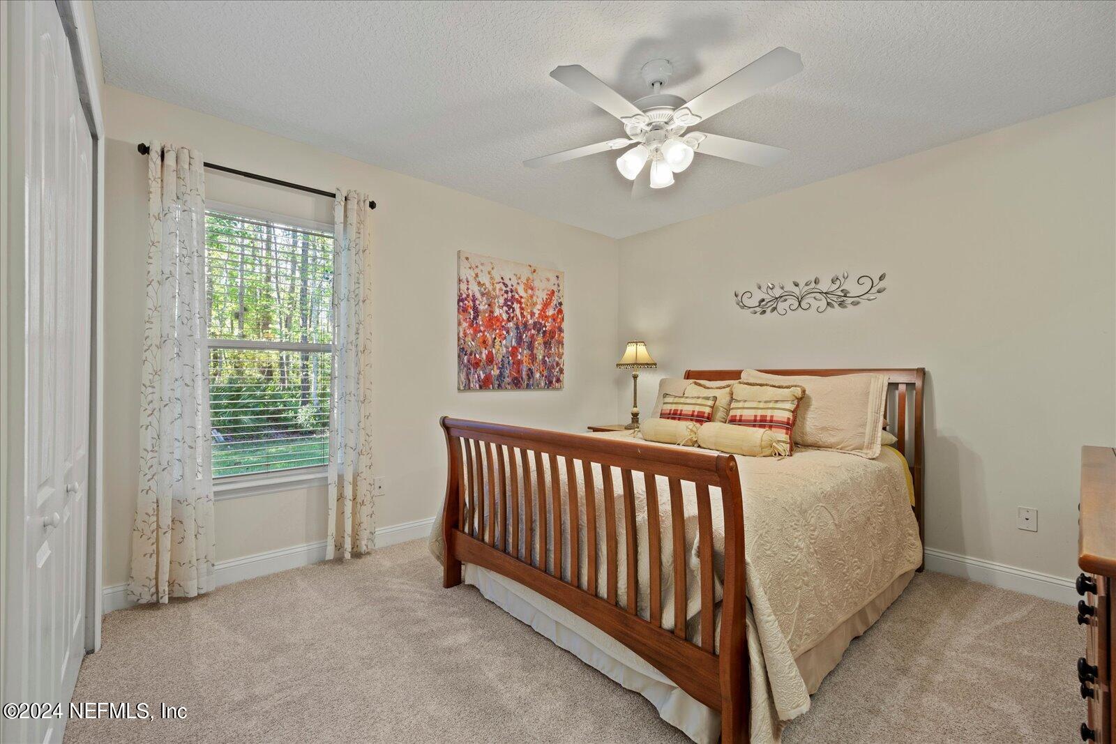 1283 Paradise Pond Road St. Augustine, FL 32092 - Photo 25 of 47 a bed room with a bed and a chandelier