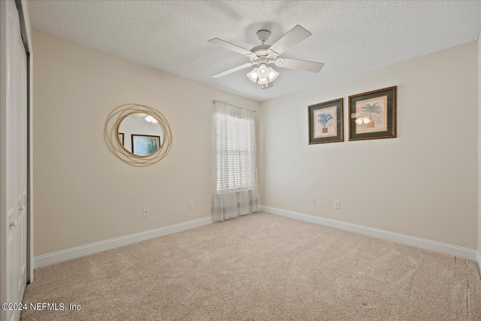 1283 Paradise Pond Road St. Augustine, FL 32092 - Photo 28 of 47 an empty room with a mirror and fan