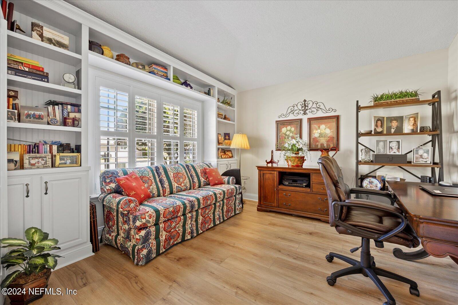 1283 Paradise Pond Road St. Augustine, FL 32092 - Photo 5 of 47 a living room with furniture a rug and a bookshelf