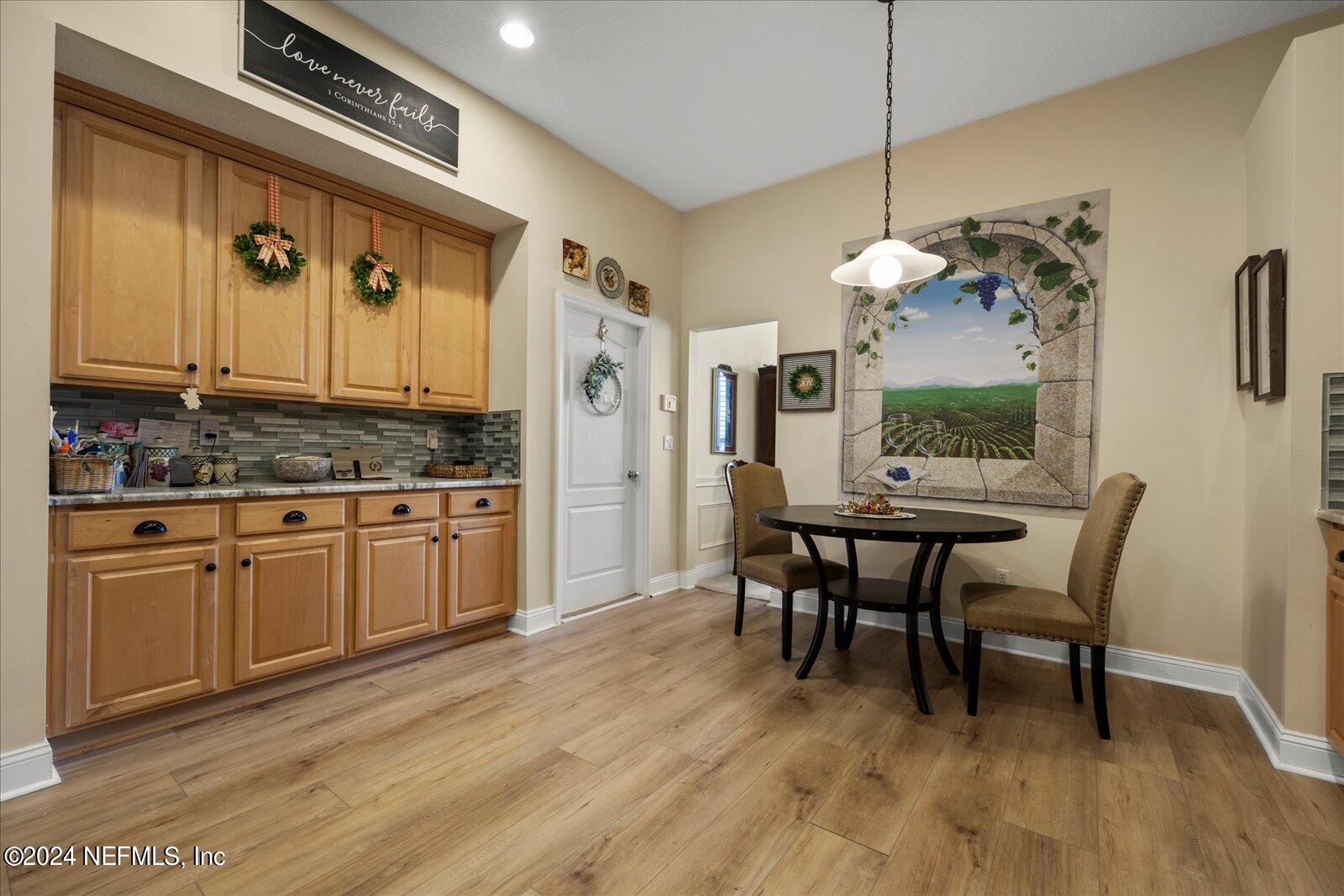 1283 Paradise Pond Road St. Augustine, FL 32092 - Photo 10 of 47 a kitchen with stainless steel appliances granite countertop a kitchen island hardwood floor sink stove dining table and chairs