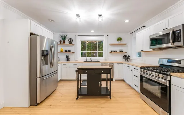 a kitchen with stainless steel appliances granite countertop a refrigerator stove microwave and sink