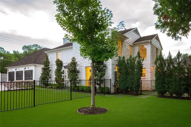 a front view of a house with a yard and trees