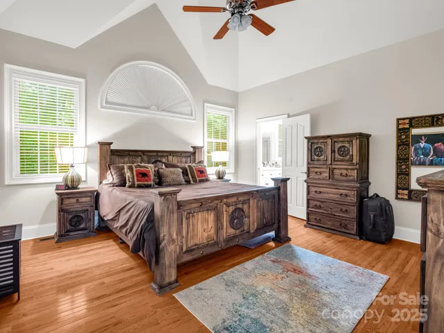 a bedroom with a bed a dresser and a large window