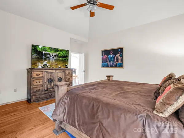 a bedroom with a bed a dresser and a chandelier