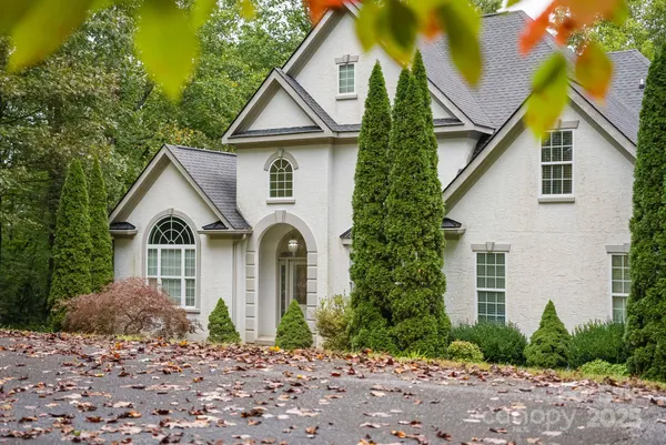 a front view of a house with a yard and trees