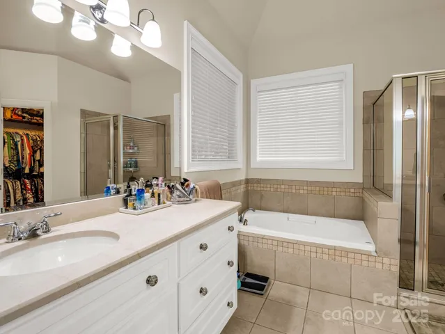 a bathroom with a granite countertop sink a large mirror and a bathtub with shower