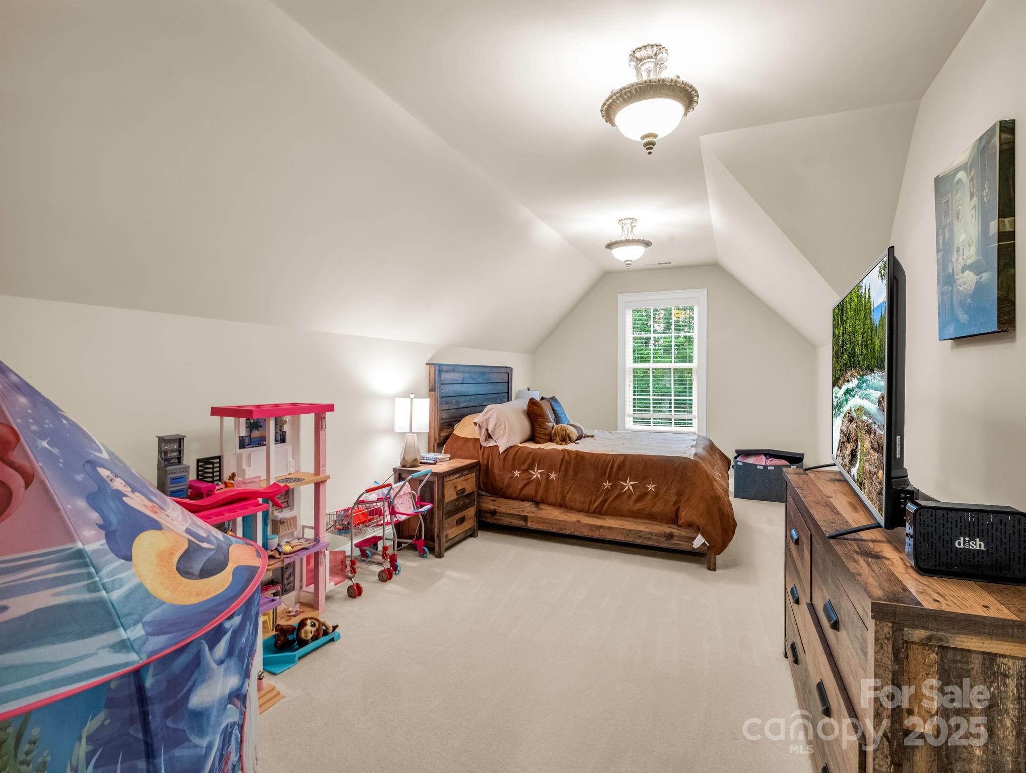 45 Brown Bear Ridge Trail Zirconia, NC 28790 - Photo 29 of 47 a bedroom with bed and a chandelier