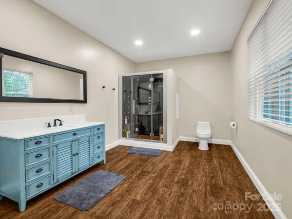 a spacious bathroom with a toilet a sink and mirror