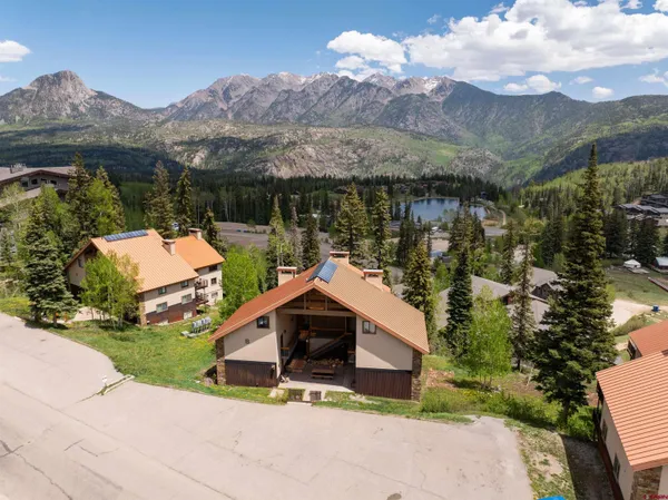 a backyard of a house with a yard and mountain view in back