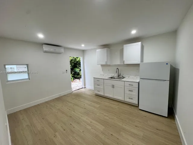a kitchen with granite countertop white cabinets and white appliances