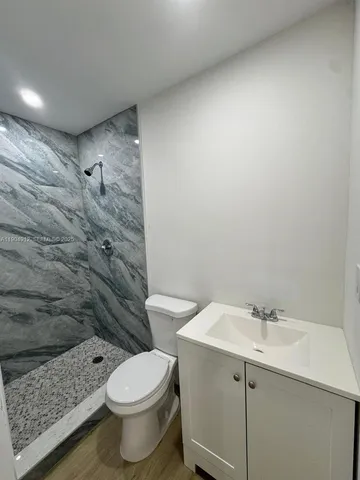 a bathroom with a sink a toilet and shower