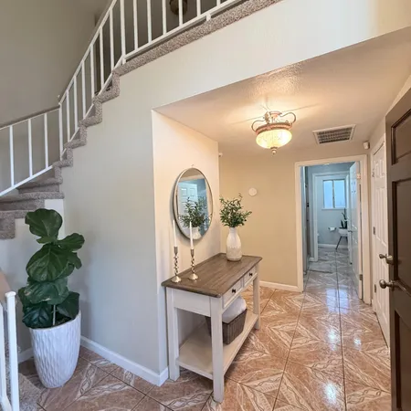 a view of a hallway to a livingroom with furniture