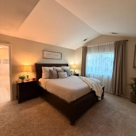 a spacious bedroom with a bed and window