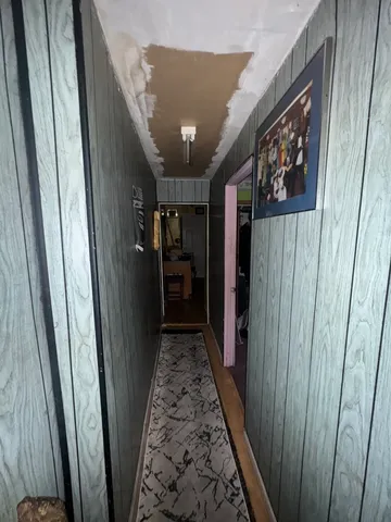 a view of a hallway with wooden floor and stairs