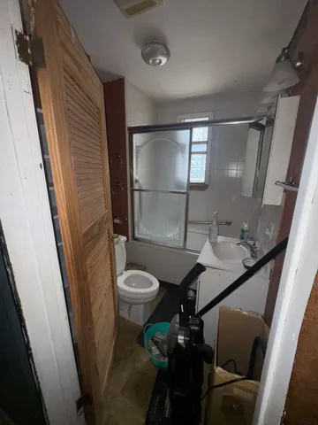 a bathroom with a sink a toilet a tub and shower