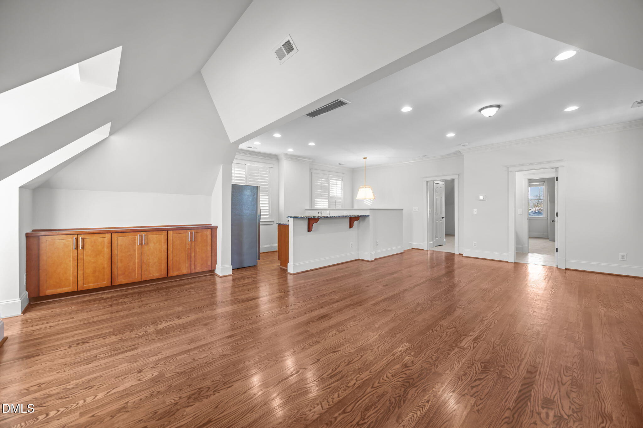 1705 Carson Street Raleigh, NC 27608 - Photo 32 of 47 a view of an empty room with wooden floor and a kitchen
