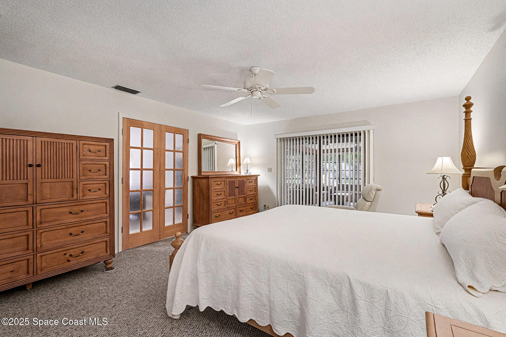 265 Mockingbird Lane Merritt Island, FL 32953 - Photo 16 of 34 a spacious bedroom with a bed a dresser and a window