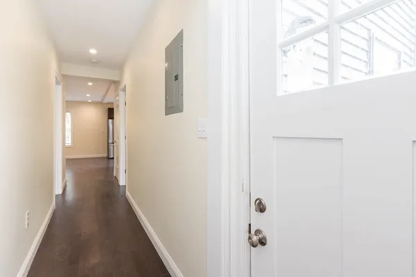 a view of a hallway with wooden floor and staircase
