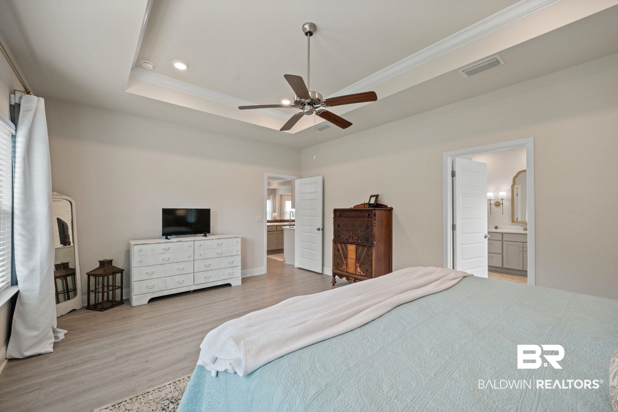 681 Calibre Street Fairhope, AL 36532 - Photo 31 of 56 Bedroom with light hardwood / wood-style flooring, ensuite bath, ceiling fan, and a tray ceiling